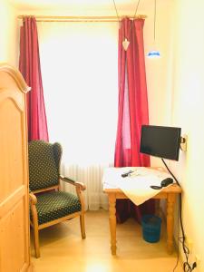 Hotel Bairischer Hof في ماركتردفيتس: غرفة بها مكتب مع جهاز كمبيوتر وكرسي