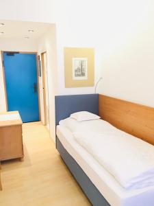Cama grande en habitación con puerta azul en Hotel Bairischer Hof, en Marktredwitz
