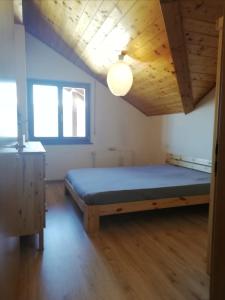 - une chambre avec un lit et un plafond en bois dans l'établissement Apartment Sant'Andrea, Brixen - Plose Ski, Hike, Bike, Nature, à SantʼAndrea in Monte