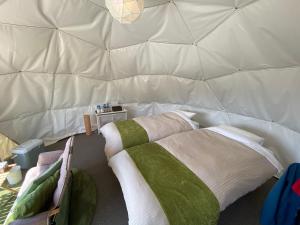 
a bed with a blanket and pillows on top of it at Mt.Shakushi Gateway Camp in Fujiyoshida
