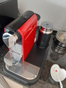 a red mixer sitting on top of a counter at Beachfront Luxury Cape Town in Bloubergstrand