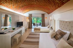 a living room with a couch and a bed and a television at El Ksar Resort & Thalasso in Sousse