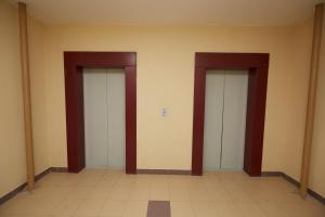 three elevator doors in a room with a tile floor at Апартаменты на Геологоразведчиков in Tyumen