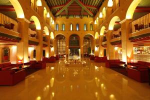 a large lobby with red chairs and a fireplace at El Ksar Resort & Thalasso in Sousse