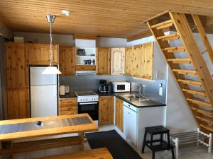 アカスロンポロにあるKelomaja Ylläsの木製のキャビネットと木製の階段付きのキッチン