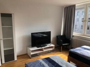 a living room with a television on a stand with a chair at Micha's Ferienwohnung in Duisburg