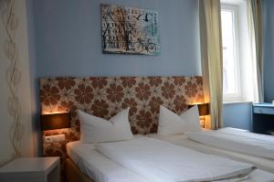 Hotel Rheinstein في روديشيم أم راين: غرفة نوم بسريرين مع وسائد بيضاء