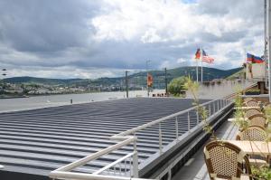 un grupo de bancos y banderas en un muelle en Hotel Rheinstein, en Rüdesheim am Rhein