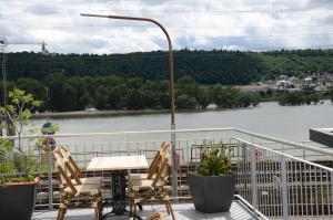 einen Tisch und Stühle auf einem Balkon mit Flussblick in der Unterkunft Hotel Rheinstein in Rüdesheim am Rhein