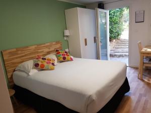 a bedroom with a large white bed with pillows at Le Thimothée : Hôtel & Studios in Saint-Raphaël