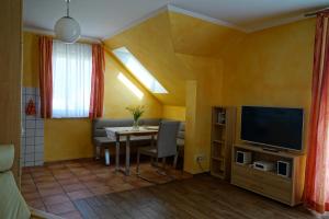 ein Wohnzimmer mit einem Tisch und einem TV in der Unterkunft Ferienwohnung Koserow in Ostseebad Koserow