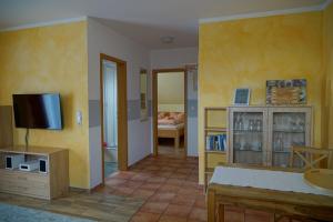 a living room with yellow walls and a television at Ferienwohnung Koserow in Koserow