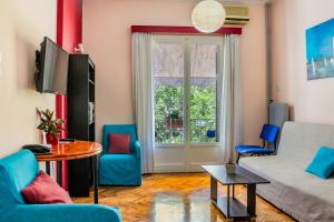 uma sala de estar com um sofá e cadeiras e uma janela em Travel Resort em Atenas