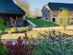 an old stone house with a garden in front of it at Gîte La Planhe in Bozouls
