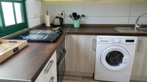 a kitchen with a washing machine and a sink at Enjoy days of dreams in paradise, 2 BR with POOL in Maspalomas
