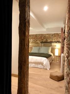a bedroom with a bed with a stone wall at Le 20 in Cintegabelle