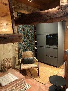 a kitchen with a stove and a chair in a room at Le 20 in Cintegabelle