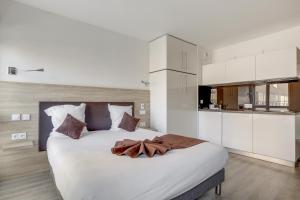 a bedroom with a large bed with white cabinets at All Suites Appart Hôtel - Choisy-le-Roi in Choisy-le-Roi
