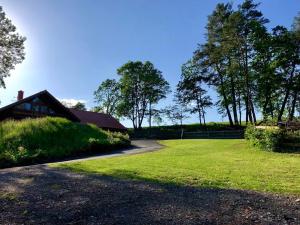 a grassy field with a house in the background at Dům nad Pržnem in Jablŭnka