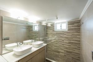 a bathroom with two sinks and a large mirror at villa nicol in Korinthos +18 photos