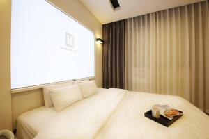 um quarto com uma cama branca e uma bandeja em Urban Stay Hotel em Gwangju