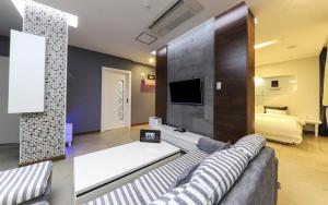 uma sala de estar com um sofá e uma televisão em Urban Stay Hotel em Gwangju