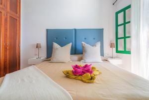 a bed with a pink flower on top of it at Casajardin in Playa Honda