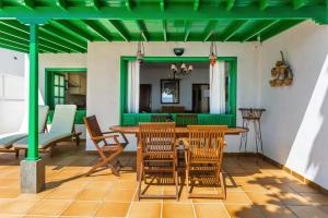een tafel en stoelen op een patio met een groen plafond bij Casajardin in Playa Honda
