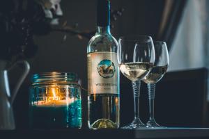 zwei Gläser Weißwein neben einer Flasche Wein in der Unterkunft Mayerhofer House in Linz