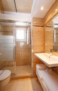 łazienka z prysznicem, toaletą i umywalką w obiekcie Les Dunes Suites w mieście Benidorm +25 zdjęć