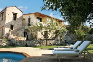 a pair of lounge chairs in front of a house at Archontiko tis Irinis in Ádhele