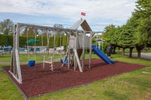 a playground with a slide and a swing at Bar Harbor Motel in Bar Harbor