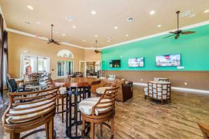 un restaurante con mesas y sillas y una pared verde en Bella Vida Resort - Welcome To Cozy 4 Beds 3 Baths Villa - Close To Disney, en Kissimmee
