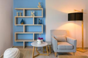 a living room with a chair and a table at Margarita's Seafront Luxury Apartment in Elounda