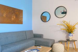 a living room with a couch and two mirrors on the wall at Margarita's Seafront Luxury Apartment in Elounda