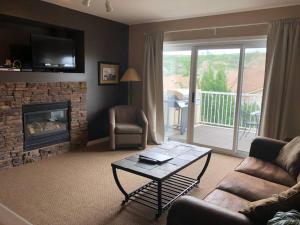 a living room with a couch and a fireplace at Paradise Canyon Golf Resort, Luxury Condo U407 in Lethbridge