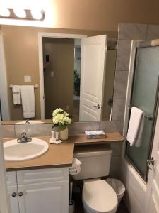 a bathroom with a sink and a toilet and a mirror at Paradise Canyon Golf Resort, Luxury Condo U409 in Lethbridge