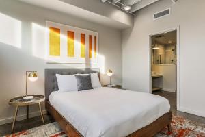 a bedroom with a large white bed and a table at Luxury Arts District Apartments in New Orleans