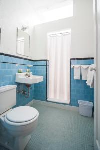 a blue tiled bathroom with a toilet and a sink at Amargosa Opera House & Hotel in Death Valley Junction
