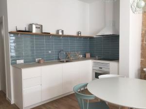 a kitchen with white cabinets and blue tiles at Cream homes Santa Catalina ETV in Palma de Mallorca