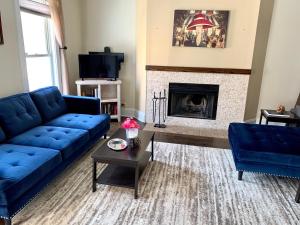 sala de estar con sofá azul y chimenea en 5 Bedroom House in Best Location Parking Fireplace Back Yard Home office en Chicago