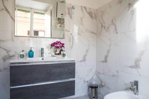 a white bathroom with a sink and a mirror at Pink Intimate Jacuzzi Suite Trastevere - Top Collection in Rome
