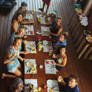 a group of people sitting around a table eating food at Casa Dunas da Barrinha in Barrinha