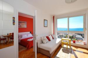 a bedroom with a couch and a bed and a window at Apartment Vana in Split