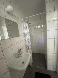 a white bathroom with a sink and a shower at Bungalows Hoefbos in Otterlo