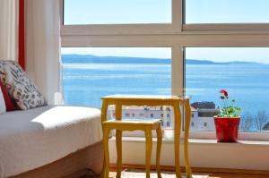 a bedroom with a bed and two chairs in front of a window at Apartment Vana in Split