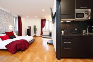 sala de estar con cama y cocina en Black Enchanting Jacuzzi Suite Trastevere - Top Collection, en Roma