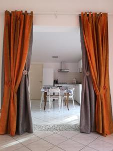 uma sala de estar com cortinas cor de laranja e uma mesa em Sul Confine em Cervia