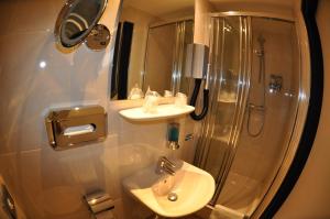 W łazience znajduje się prysznic, umywalka i toaleta. w obiekcie Budget Hotel Le Beau Rivage w mieście Middelburg