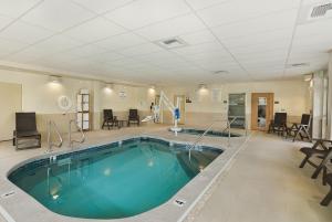 a large swimming pool in a large room with chairs at Oxford Suites Bellingham in Bellingham